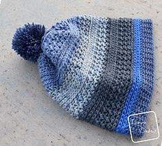 a blue and gray knitted hat laying on the ground