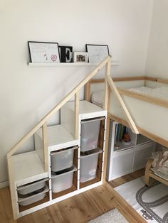 a dollhouse bed is built into the side of a wall with shelves and drawers