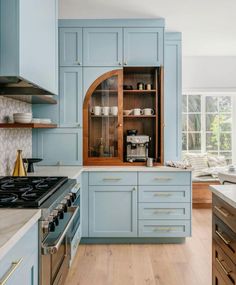 a kitchen with blue cabinets and wooden floors