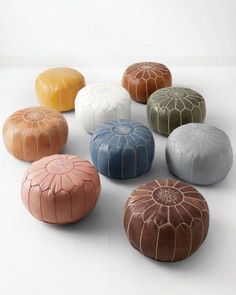 an assortment of poufles sitting on top of a white table next to each other