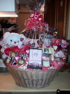 a teddy bear sitting in a basket filled with lots of love and valentine's gifts