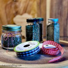 three jars filled with different types of blue and green stuff on top of a wooden table