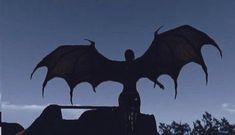 a large black dragon sitting on top of a building