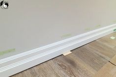 the corner of a room that has been painted white with some green tape on it