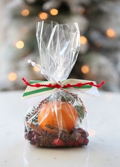 a bag filled with fruit sitting on top of a table next to a christmas tree