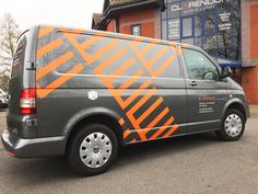 an orange and gray van parked in front of a building