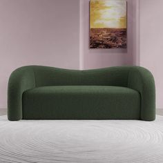 a green couch sitting on top of a white floor next to a pink wall and painting