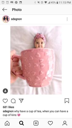 a baby in a pink cup with hearts on it's side and the caption says,