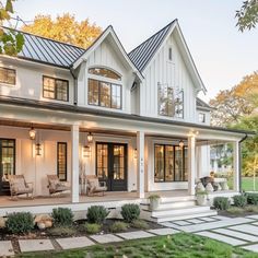 a white house with lots of windows on the front and side of it's porch