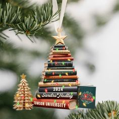 a christmas tree ornament with books stacked on it and a star hanging from the top