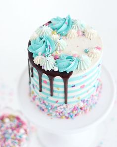 a white cake with blue frosting and sprinkles