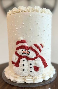 a decorated cake with two snowmen on it