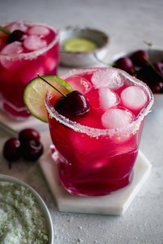 two glasses filled with ice and cherries