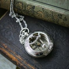 Bronze sundial and compass in one.On either a 28" necklace chain or a thick mens pocket chain.The dial on the front of the sundial can be folded down to fit in a pocket comfortably. Pressing the button on the top pops open the front to expose the compass. Each purchase comes in a gift box. Silver Metal Pocket Watch With Compass Design, Vintage Stainless Steel Jewelry With Compass Design, Silver Pocket Watch With Compass Design, Antique Silver Pocket Watch With Compass Design, Press The Button, Compass, Chains Necklace, Silver Chain, Chain Necklace