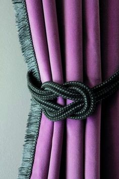 a purple curtain with a black rope attached to it