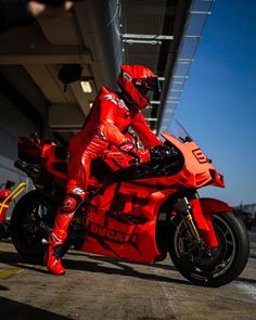 a man in red is sitting on a motorcycle