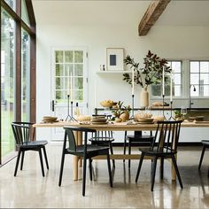 a dining room table with chairs and plates on it