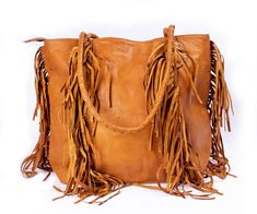 Elevate your everyday style with this tan suede fringe bag, a bohemian treasure with western flair. Expertly handcrafted, this leather tote is as practical as it is stylish, offering ample space for your daily must-haves. It's the ultimate boho purse for fashion-forward individuals who dare to make a statement. Perfect for festivals, weekend adventures, or just your daily commute. 🌞👜 🌾 Premium suede material for a soft, luxurious feel. ✨ Features playful fringe detailing for a boho-chic look. Moroccan Bags, Leather Fringe Bag, Brown Leather Tote Bag, Boho Purse, Bridesmaid Tote Bags, Free Spirit Style, Moroccan Leather, Brown Leather Totes, Fringe Bags