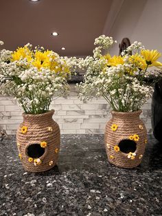 two vases filled with yellow and white flowers