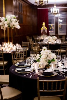 the tables are set with white flowers and black linens for an elegant dinner party