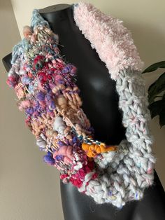 a close up of a mannequin wearing a multicolored knitted scarf