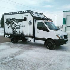 a white truck parked in a parking lot with trees on it's side and black trim