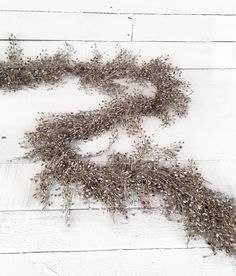 dried flowers are laying on a white wooden surface