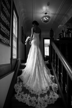 a woman in a wedding dress is walking down the stairs