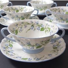 a table topped with cups and saucers covered in blue floral designs on white plates