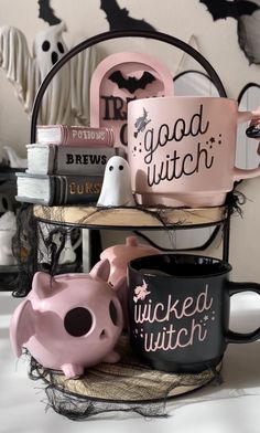 two black and pink coffee mugs sitting on top of a shelf