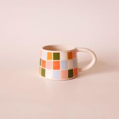 a multicolored coffee cup sitting on top of a table