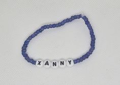 a blue beaded bracelet with the word anny written in white letters on it