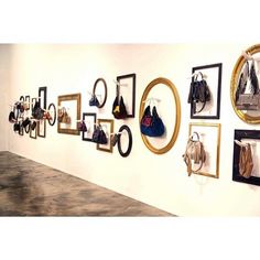 a wall with many different purses hanging on it's sides and some mirrors