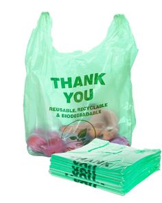 a plastic bag filled with fruit and vegetables next to a pile of bags that say thank you