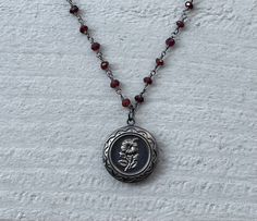 This necklace is handmade with a 3mm genuine garnet rosary chain and a flower locket pendant. The locket opens up so you can place a photo inside.  This necklace is hypoallergenic. (Cadium free, lead free, and nickel safe) Garnet is an energizing stone that promotes passion and love.  The necklace comes in a ribbon-wrapped box, ready to be gifted. If you would like to leave a note, you can do so during checkout.