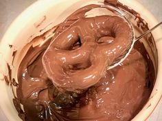 chocolate frosted doughnuts in a bowl with a spoon