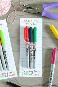 three markers and some scissors on a table