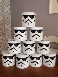 a stack of toilet paper cups with black and white designs on the top, sitting on a wooden table