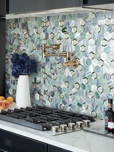 a stove top oven sitting next to a vase filled with flowers and bottles on the counter