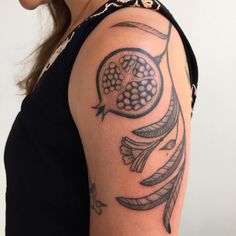 a woman's arm with a tattoo on it that has an owl and feathers