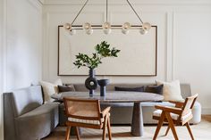 a living room filled with furniture and a large painting on the wall above a table