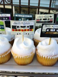 cupcakes with white frosting and cassette labels on them