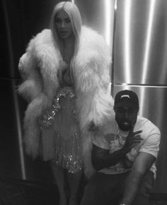 a man sitting next to a woman in front of a refrigerator covered in sequins