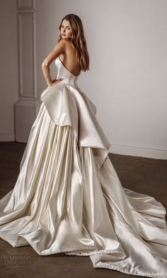 a woman in a white dress is standing on the floor with her back to the camera