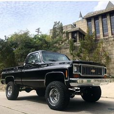 a black pickup truck parked in front of a house