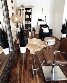 a living room filled with furniture and a large mirror on top of a hard wood floor