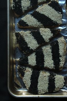 several slices of cake with black and white frosting on them sitting in a pan