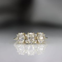 three stone diamond ring on reflective surface with reflection