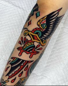 a tattoo on the arm of a man with an eagle and cross in his hand