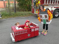 a woman and two children in a fire truck costume